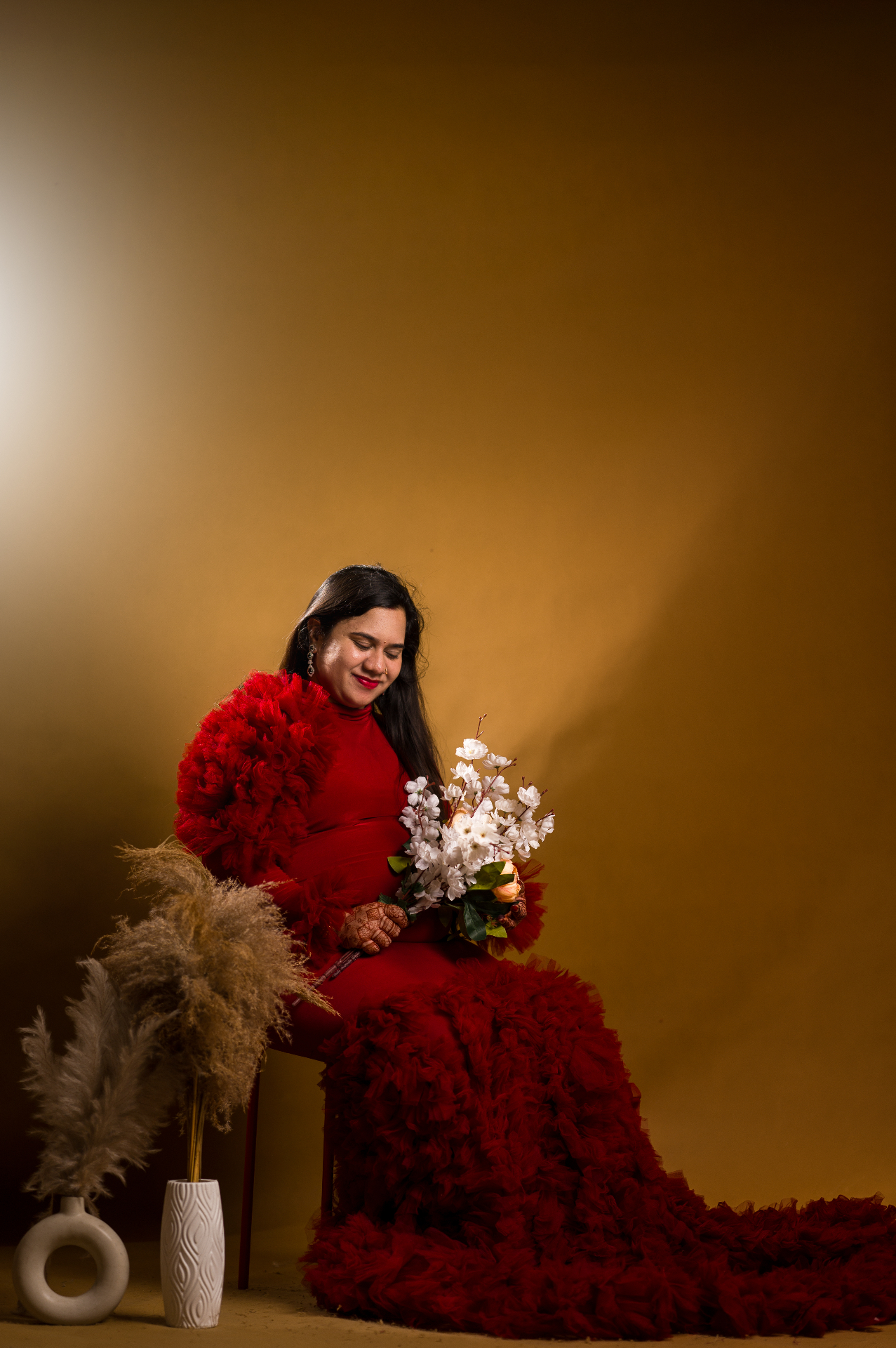 Expecting mother seated with flowers